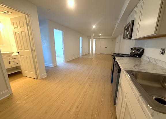 A kitchen with wooden floors and white walls.