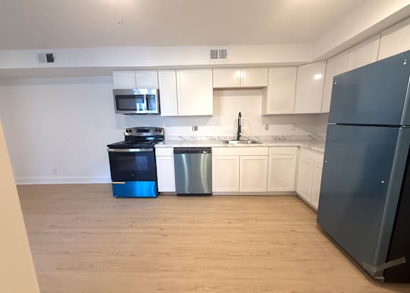 A kitchen with a blue fridge and a black stove.