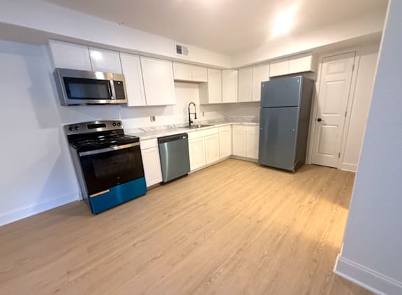 A kitchen with a blue fridge and white cabinets.