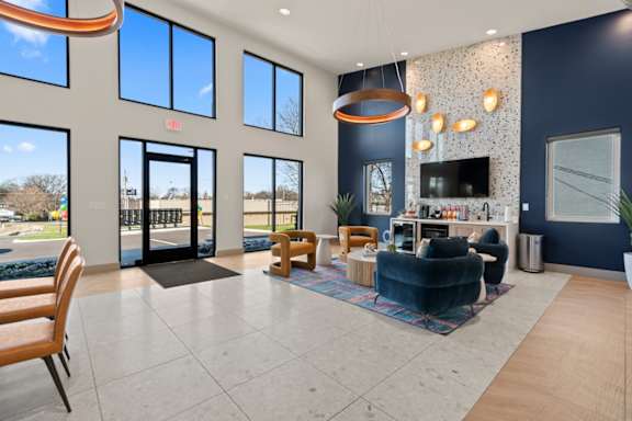 Leasing office clubhouse at The Canvas Apartments Nashville with coffee bar and seating area with navy blue and gold chairs.