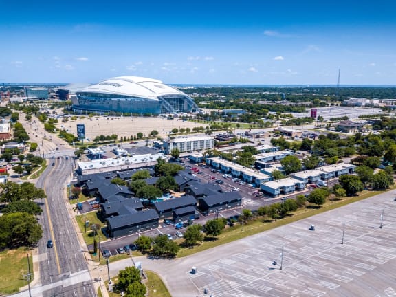 aerial view of Stadium 700 luxury apartments and off-street parking lot. AT&T stadium is within walking distance in the background