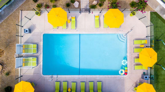 aerial shot of the community pool at fusion apartment complex in Las Vegas, NV with yellow umbrellas and green lounge chairs