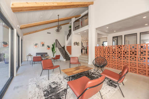 Fusion 35 clubhouse with orange chairs, a staircase, and a wall of orange cubes.