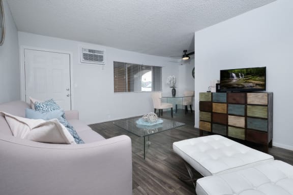 Living room in two bedroom apartment in Las Vegas near UNLV with large window and wood-style plank flooring