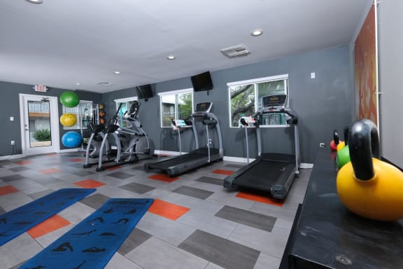 Gym at Fifteen 50 Las Vegas apartments with cardio machines and weight training equipment