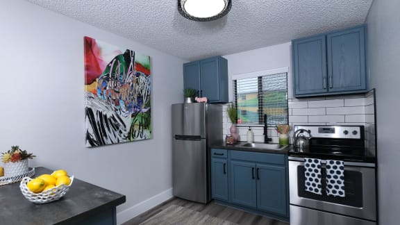 kitchen in fusion 1-bedroom apartments in  Las Vegas with custom tile backsplash and stainless steel appliances.