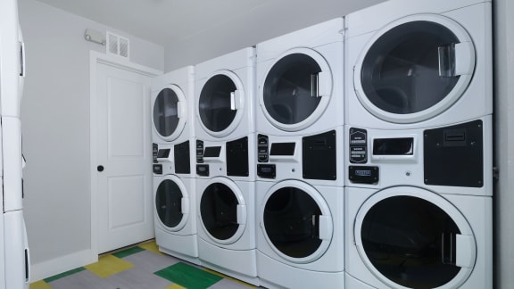 on-site laundry room at Fusion Las Vegas apartment complex with large washers and dryers.
