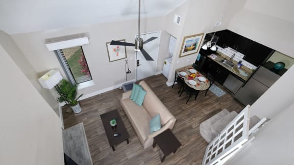 View of living area from loft in furnished 1-bedroom apartment at Fusion Orlando with large ceiling fan and breakfast nook