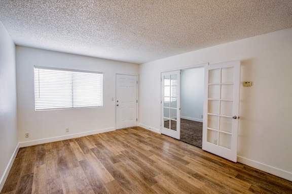 Interior French doors to living room in one bedroom apartment in Las Vegas near UNLV with white trim and silver knobs.