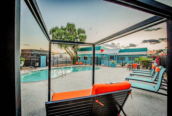 A pool area with a bench and a fence.
