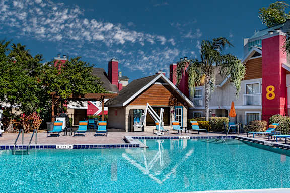 A pool with a wooden building in front of it at Fusion Orlando furnished apartments.