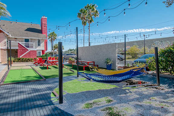 Lounge area at Fusion Orlando Apartments with outdoor hammock and a patio.