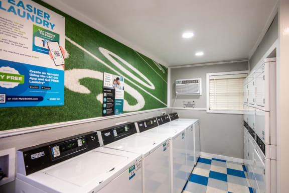 brand new on-site laundry room at Stadium 700 luxury apartments in Arlington, TX with green mural wall.