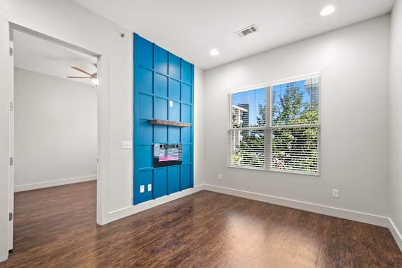 A room with a blue wall and wooden floors.