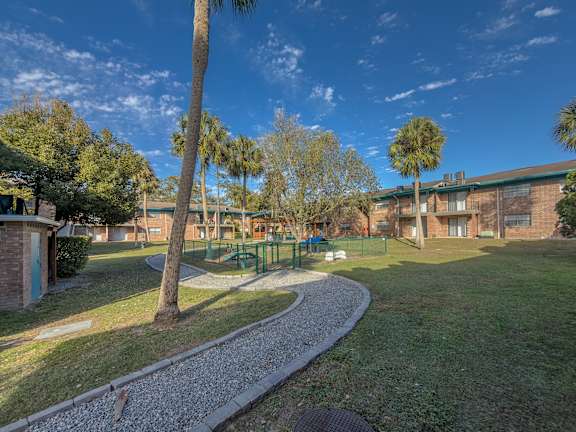 A pet park in the middle of Watermarc Apartments community with brick buildings and grass