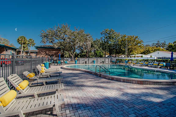 A pool area with sun loungers and a clear blue sky at Watermarc Apartments Lakeland, FL