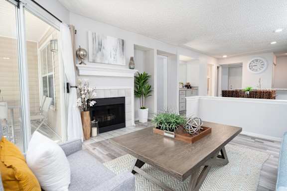 A living room with a fireplace and a grey couch.
