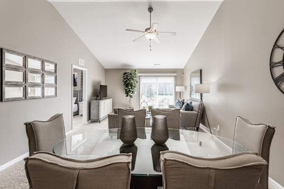 A dining room with a glass table and chairs.