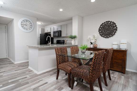 A kitchen with a table and chairs.