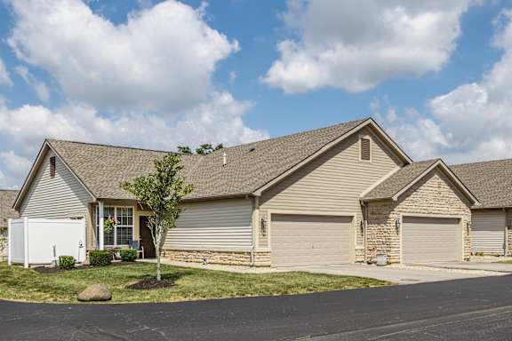 A house with a white garage door and a brown roof.