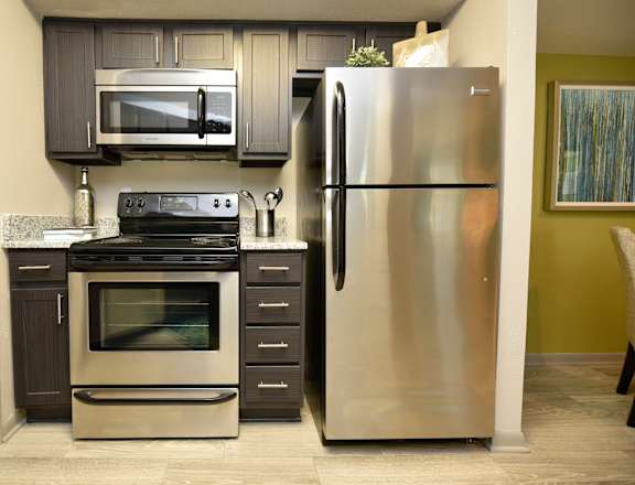 a kitchen with stainless steel appliances and black cabinets