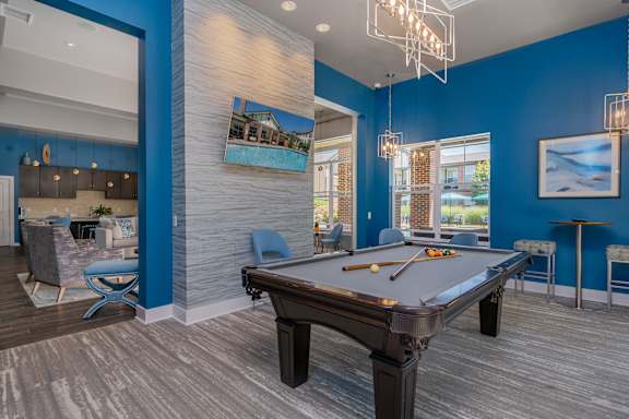 A pool table is in the middle of a room with blue walls.