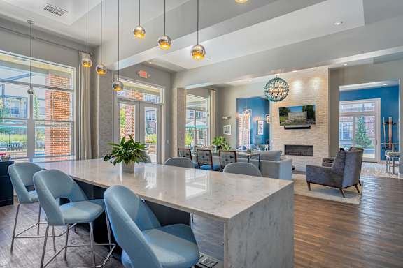 A modern dining room with a long table and grey chairs.