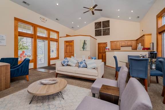 A living room with a white couch and blue chairs.