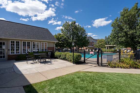 A sunny day at the poolside with a building in the background.