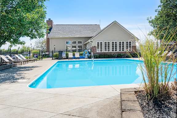 A swimming pool in front of a house.