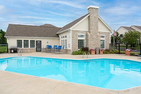 A house with a pool in front of it.