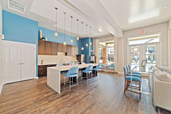A kitchen with a dining table and chairs in the middle of the room.