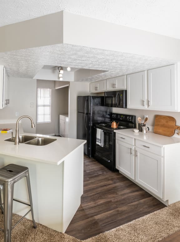 Apartments in Westerville, OH for Rent - Fairway Lakes - Kitchen with White Cabinets, White Countertops, Black Appliances, and Attached Laundry Room.
