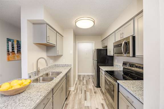 A kitchen with a bowl of lemons on the counter.