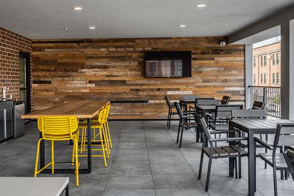 A dining area with a wooden wall and chairs.