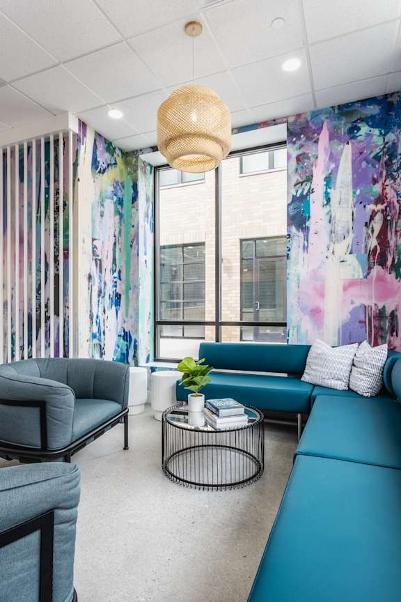 A room with a blue couch and a black chair.