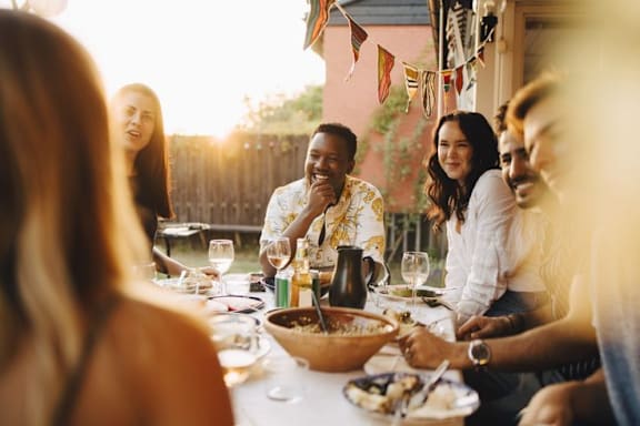 A group of people are gathered around a table enjoying a meal together.