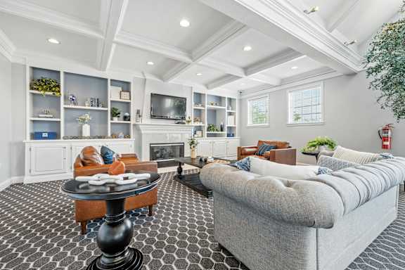 A living room with a grey couch and a black and white checkered floor.