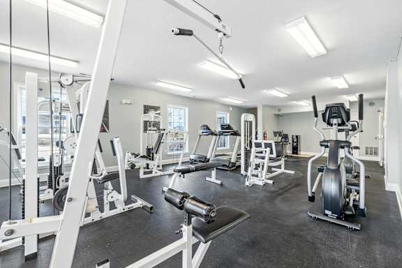A spacious gym with a variety of equipment including treadmills, weight machines, and benches.