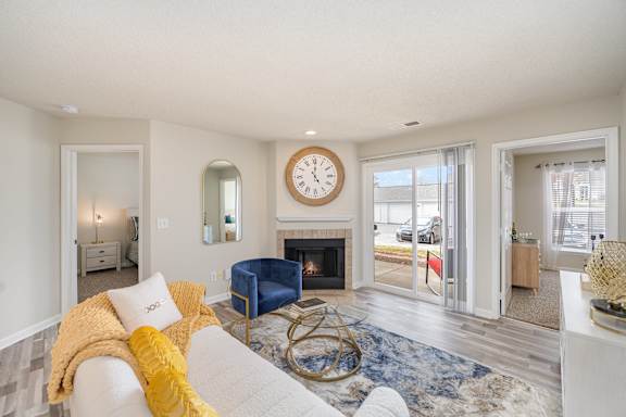 A living room with a fireplace and a clock on the wall.