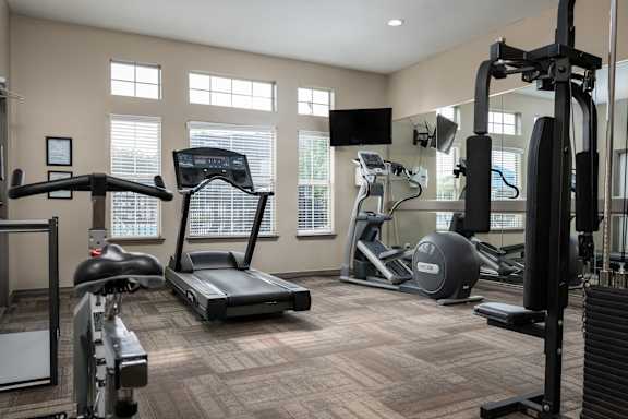 A spacious home gym with a variety of exercise equipment.