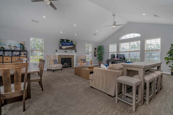 A spacious living room with a fireplace and a dining table set up.