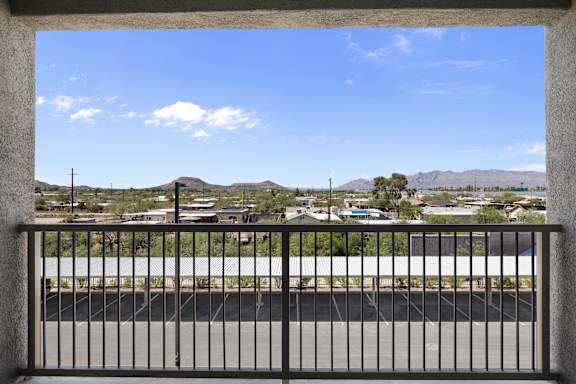 A view from a balcony looking out at a road and mountains.