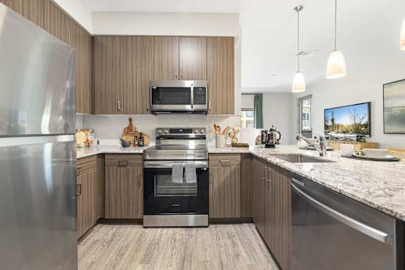 A modern kitchen with wooden cabinets and stainless steel appliances.