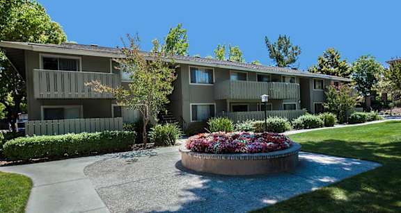 Apartment complex with a flower bed in front at Cherrywood Apartments, San Jose, 95118