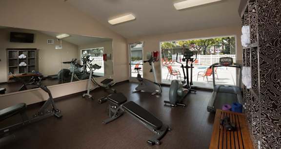 A gym with treadmills, exercise bikes, and other equipment at Cherrywood Apartments, San Jose, California
