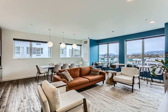 A living room with a couch, chairs, and a dining table.