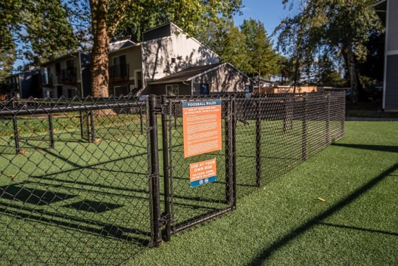 a sign on a fence in front of a tennis court