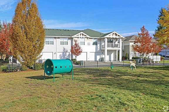 two children playing in a park in front of an apartment building