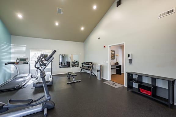 A gym with treadmills, elliptical machines, and other exercise equipment.